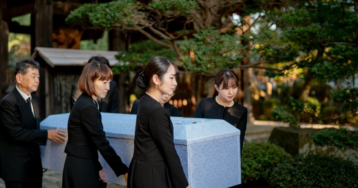 遺族が棺を運んでいる様子