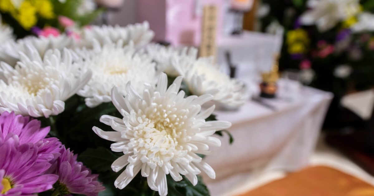 白い菊の花が供えられた祭壇の前に飾られている