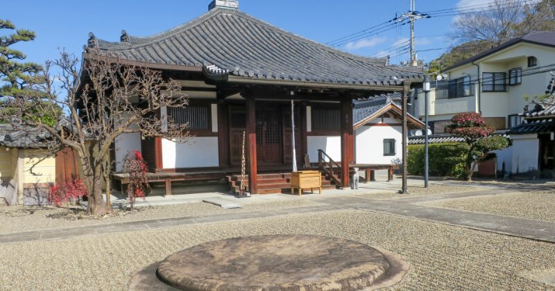 日本の伝統的な木造寺院とその周囲の庭園風景